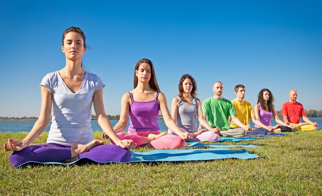 colorful photo of people meditating outdoors