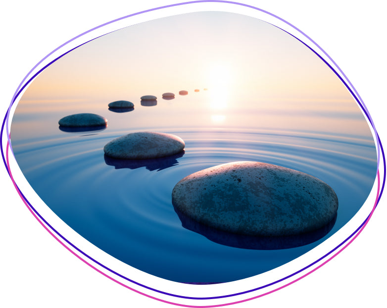 A serene scene of smooth, round stones arranged in a straight line across calm water at sunset. The tranquil atmosphere evokes a sense of peace and balance.